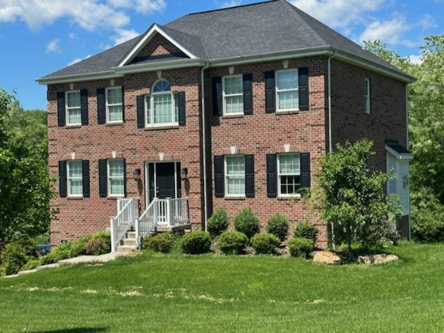 colonial home featuring a front lawn