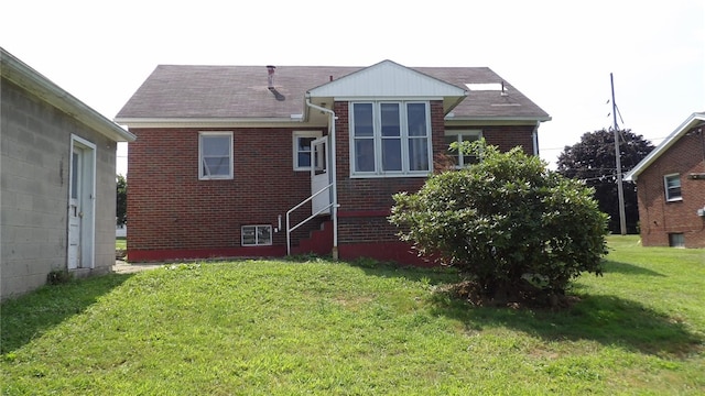 rear view of house featuring a yard