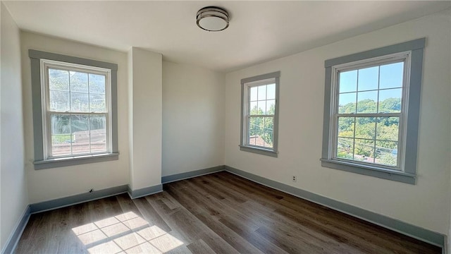 spare room with dark wood-style floors and baseboards