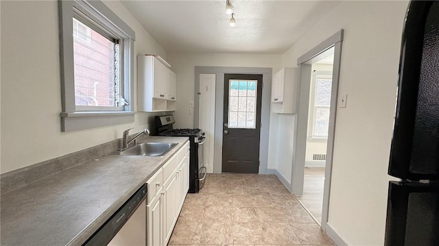 kitchen featuring visible vents, baseboards, white cabinets, stainless steel appliances, and a sink