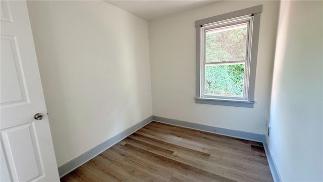 spare room featuring wood finished floors and baseboards