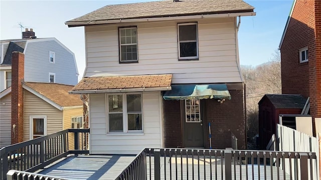 back of property with roof with shingles