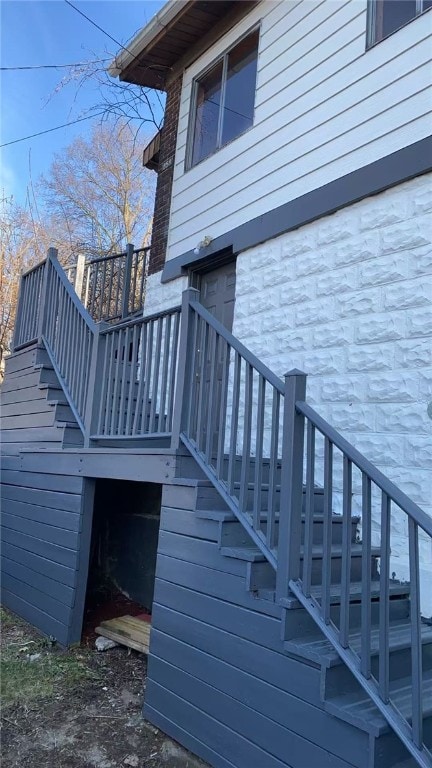 exterior space with stairway and stone siding