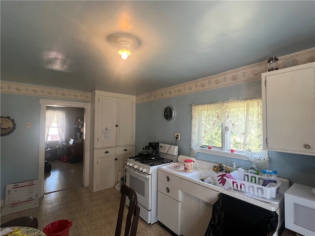 kitchen featuring white cabinets and gas range gas stove