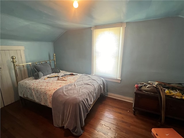 bedroom with lofted ceiling and dark hardwood / wood-style floors