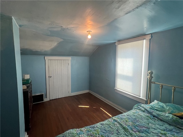 bedroom with vaulted ceiling and dark hardwood / wood-style floors