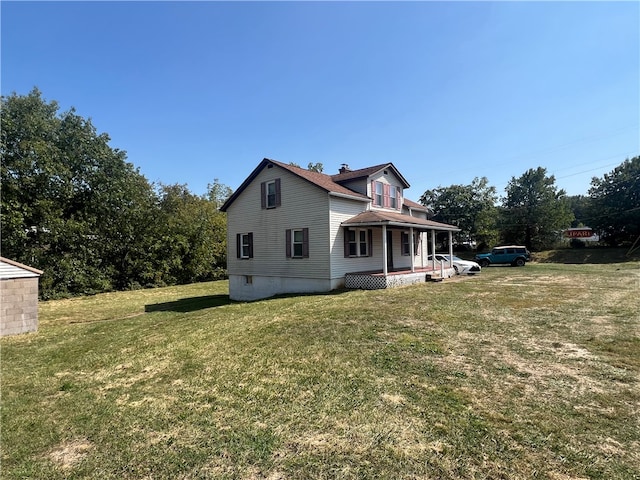 back of house with covered porch and a lawn