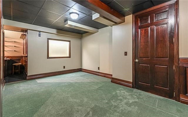 basement featuring a paneled ceiling and carpet flooring