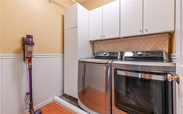 laundry room with cabinets, light hardwood / wood-style flooring, and washing machine and clothes dryer