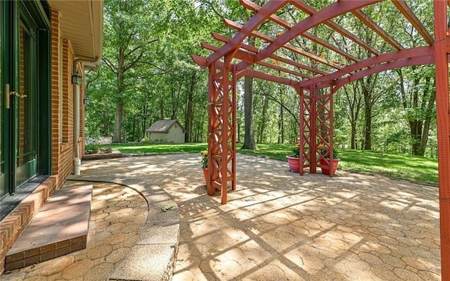 view of patio / terrace with a pergola and a storage unit