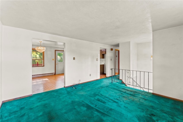 empty room with a baseboard heating unit, an inviting chandelier, and a textured ceiling