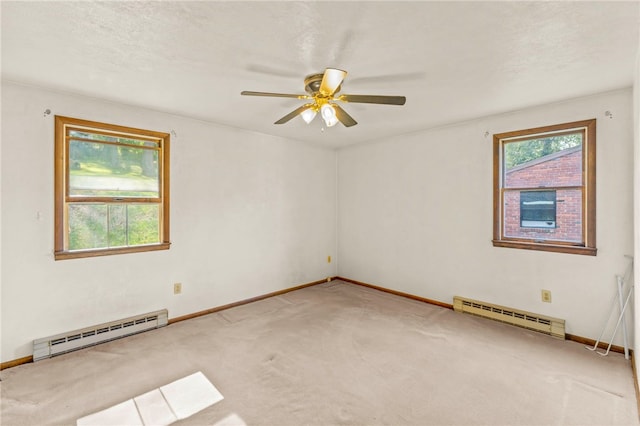 spare room with a baseboard radiator, carpet, and ceiling fan