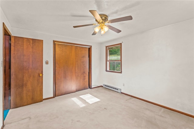 unfurnished bedroom with a closet, ceiling fan, light colored carpet, and baseboard heating