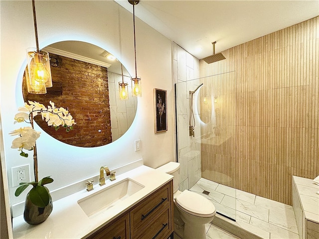 bathroom featuring toilet, a tile shower, ornamental molding, and vanity