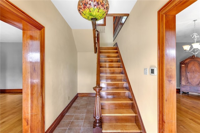 staircase featuring hardwood / wood-style flooring and a chandelier