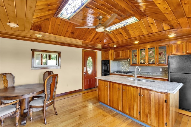 kitchen featuring black appliances, tasteful backsplash, wood ceiling, a kitchen island with sink, and ceiling fan