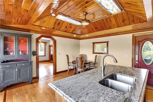 kitchen with a kitchen island with sink, sink, ceiling fan, wood ceiling, and light hardwood / wood-style floors