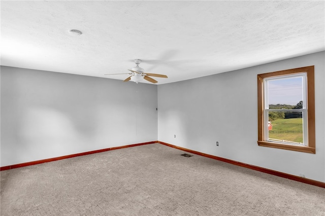 spare room with ceiling fan, a textured ceiling, and carpet floors