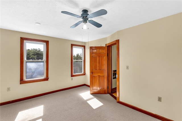 carpeted spare room featuring a textured ceiling and ceiling fan