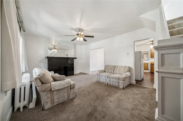 carpeted living room with ceiling fan and radiator heating unit