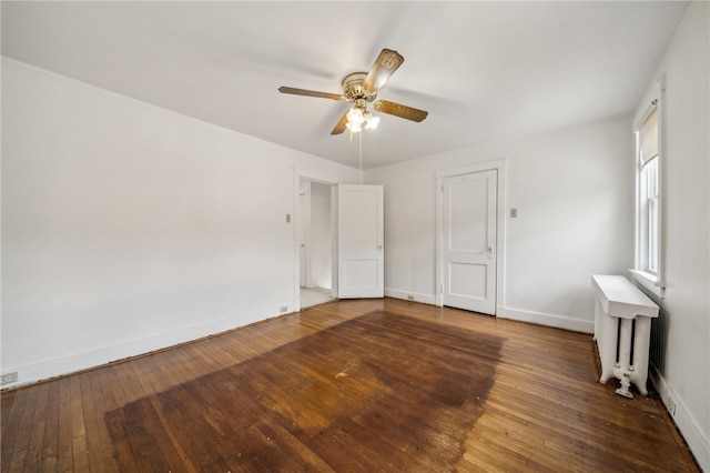 unfurnished bedroom with ceiling fan, hardwood / wood-style flooring, and radiator heating unit