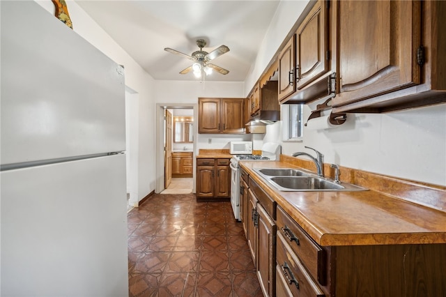 kitchen featuring white appliances, sink, and ceiling fan