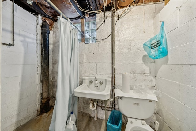 bathroom featuring toilet, a shower with shower curtain, and sink