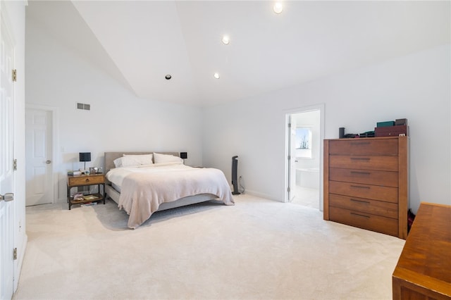 carpeted bedroom with connected bathroom and high vaulted ceiling