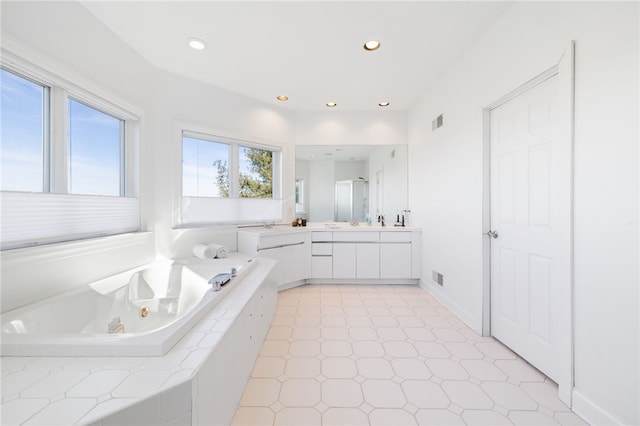 bathroom featuring vanity and tiled tub