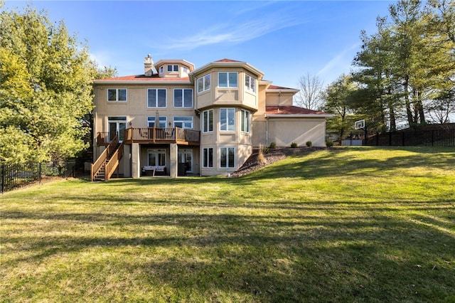 back of house featuring a wooden deck and a lawn