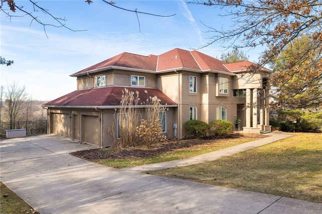 mediterranean / spanish-style house featuring a garage and a front yard