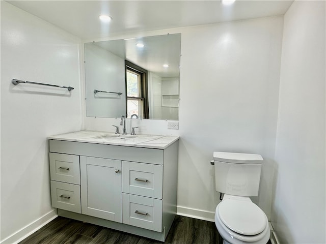 bathroom with toilet, hardwood / wood-style flooring, and vanity