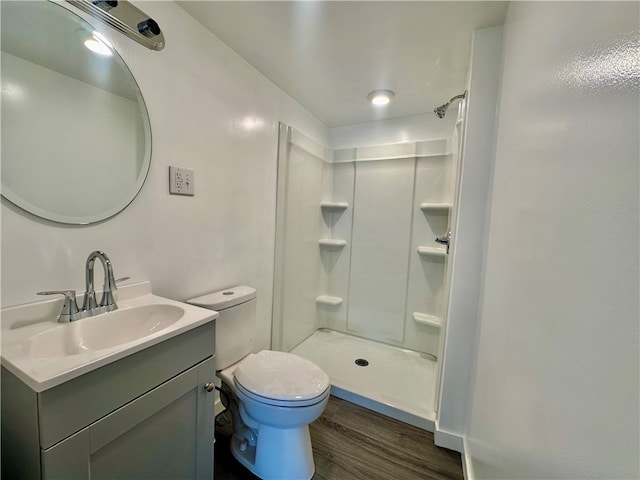 bathroom featuring a shower, wood-type flooring, toilet, and vanity