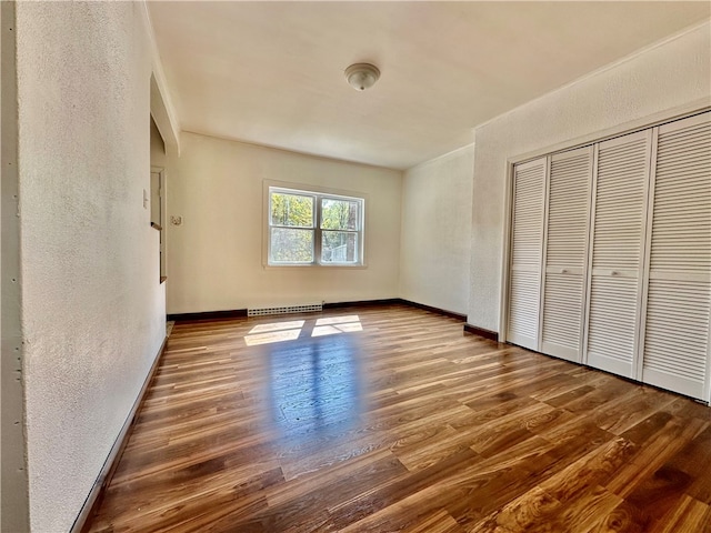 unfurnished bedroom with dark wood-type flooring and a closet