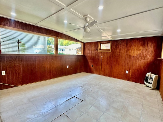 empty room with ceiling fan, wooden walls, and heating unit