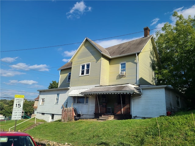 back of house with a lawn