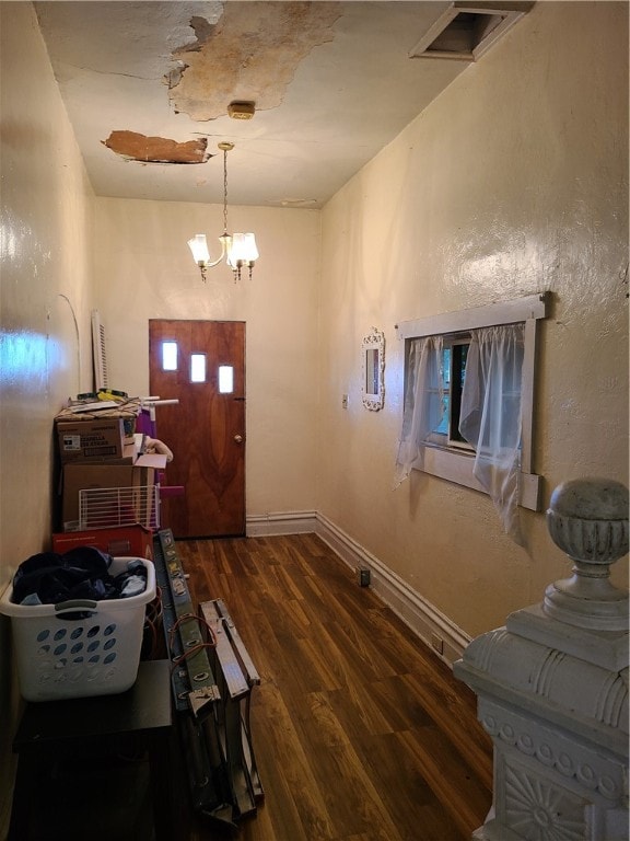 entryway with wood-type flooring and a notable chandelier