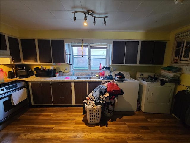 kitchen with stainless steel stove, independent washer and dryer, and hardwood / wood-style flooring