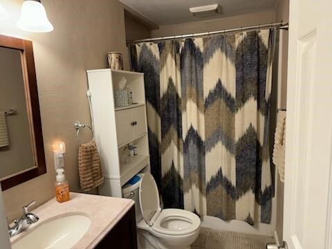 bathroom featuring vanity, toilet, and a shower with curtain