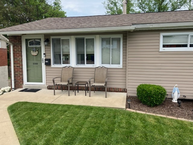 rear view of house with a lawn and a patio