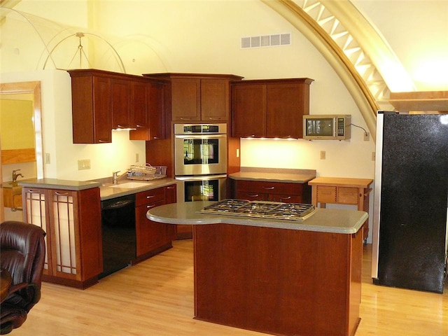 kitchen featuring light hardwood / wood-style flooring, stainless steel appliances, a kitchen island, and sink