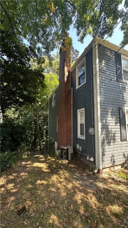 view of side of home with central air condition unit