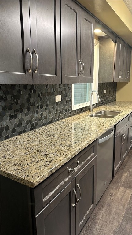 kitchen featuring backsplash, dark brown cabinetry, and stainless steel dishwasher