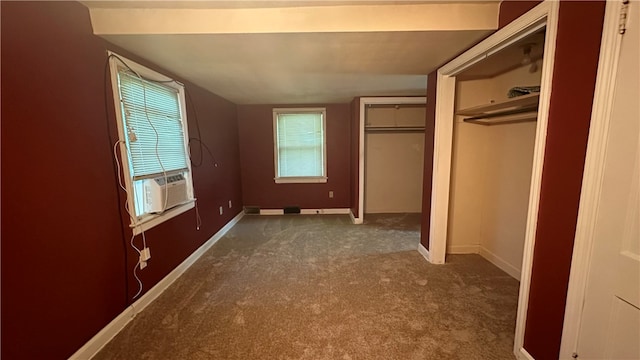 unfurnished bedroom featuring dark colored carpet, multiple windows, and cooling unit