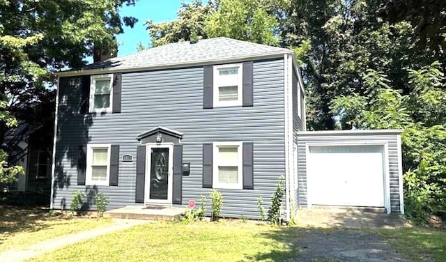 colonial house with a front lawn and a garage