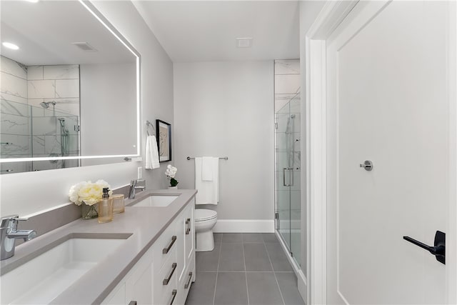 bathroom featuring vanity, toilet, tile patterned flooring, and a shower with door