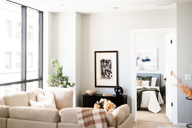 living room with light hardwood / wood-style flooring and a wall of windows