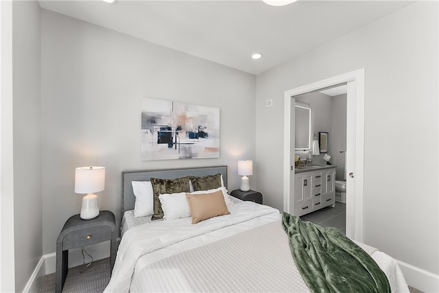 bedroom with light tile patterned floors and ensuite bathroom