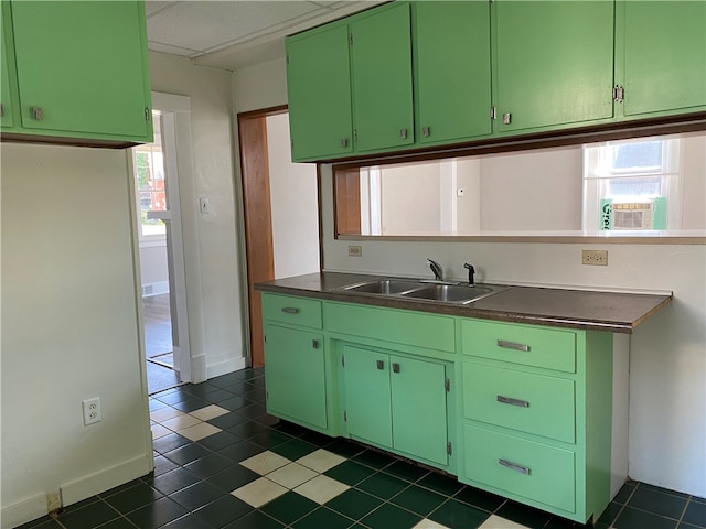 kitchen featuring dark tile patterned flooring, green cabinetry, and sink