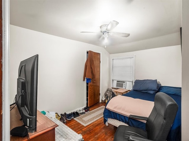 bedroom featuring hardwood / wood-style floors, cooling unit, and ceiling fan